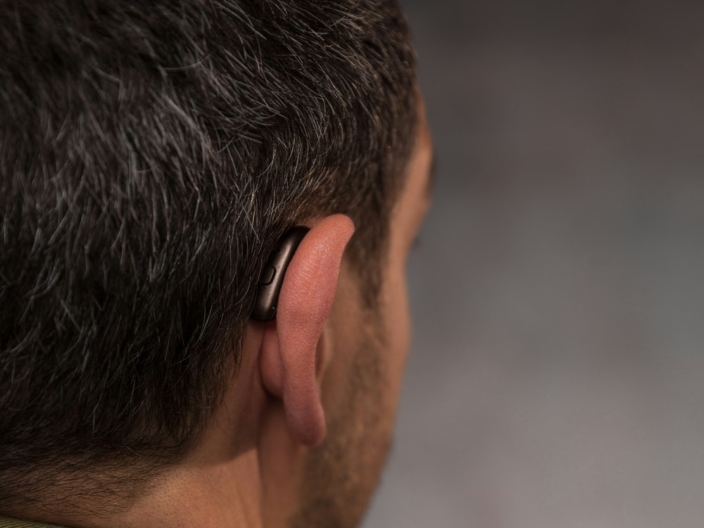 Doctor of Audiology programming a new hearing aid during a fitting appointment at Better Hearing Clinic in McAllen, TX