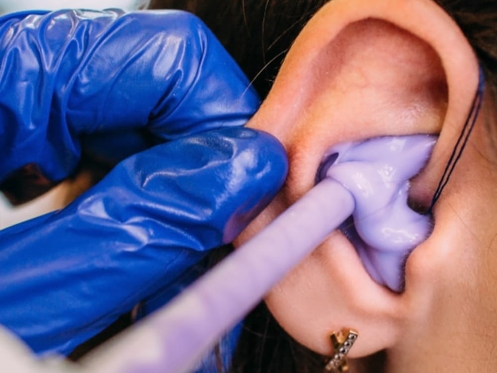 Audiologist fitting a patient with custom hearing protection at Better Hearing Clinic in McAllen, TX